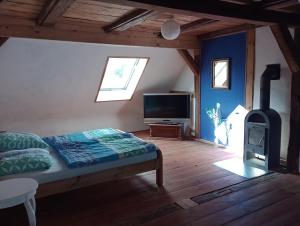 a bedroom with a bed and a wood stove at Dachkemenate im Lehmhaus in Häven