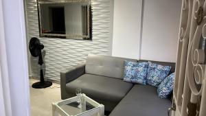 Estación El SaltoHermoso Apartamento en Junin A dos cuadras del centro comercial de la cuesta的带沙发和镜子的客厅
