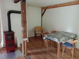 a dining room with a table and a wood stove at Dachkemenate im Lehmhaus in Häven
