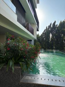 a building with a pool of water next to flowers at Luxury at Solaris Appartment in Accra