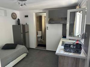 a small kitchen with a sink and a refrigerator at Bazakos Luxury Kampi Beach Studio 1 in Fournoi