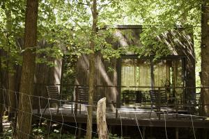 un grupo de sillas sentadas en una terraza en el bosque en Carthome - wyjątkowe miejsce leśnego wypoczynku, en Zynie 20 fotos más