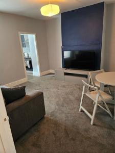 a living room with a couch and a tv and a table at One Bedroom Flat Wallsend in Old Walker