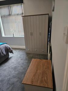 a room with a wooden table and a cabinet at One Bedroom Flat Wallsend in Old Walker