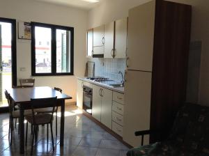 eine Küche mit einem Tisch und einem Kühlschrank in der Unterkunft Appartamenti Saverio in Posada