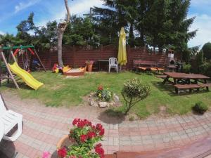 a backyard with a picnic table and a playground at Dom Gościnny Wika in Rewal