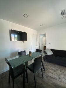 a living room with a table and chairs and a couch at Alex Guest House in Quinta do Anjo