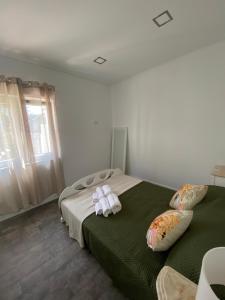 a bedroom with a bed with two towels on it at Alex Guest House in Quinta do Anjo