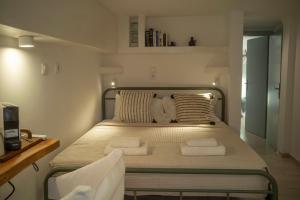 a small bedroom with a bed with towels on it at Naousa's Melody in Naousa