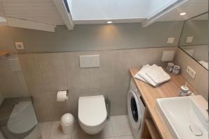 グリュックスブルクにあるDreibogen Ferienhaus Smalandのバスルーム(トイレ、洗面台、洗濯機付) +15枚の写真