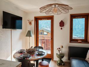 a living room with a table and a television at Le Bon' Appart studio proche centre Châtel in Châtel