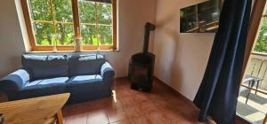 a living room with a couch and a stove at Ferienwohnungen Das Finkhaus in Simonsberg