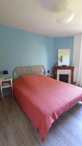 een slaapkamer met een bed met een rode deken bij Les bananiers in Bergerac