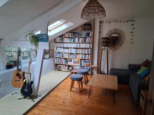 een woonkamer met een boekenplank vol boeken bij Les bananiers in Bergerac