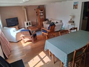 een woonkamer met een tafel, stoelen en een televisie bij Les bananiers in Bergerac +22 foto's