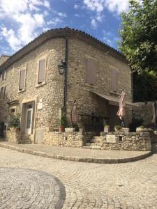 ein großes Backsteingebäude mit einem Innenhof davor in der Unterkunft Maison indépendante en Drôme Provençale in Valaurie + 8 Fotos