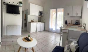 eine Küche und ein Wohnzimmer mit einem Tisch und einer Theke in der Unterkunft Maison indépendante en Drôme Provençale in Valaurie