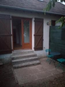 a house with a door and stairs and a chair at Maison 2 - entre ville et verdure in Saint-Pryvé-Saint-Mesmin