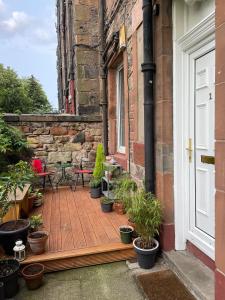 a patio with potted plants on a brick building at Quiet 1 Bed with Garden Views Near Leith & City Centre in Edinburgh