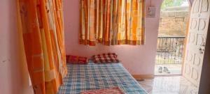 a room with a bed in front of a window at Radhesham bhakt niwas in Pandharpur