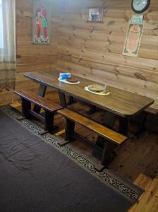 a wooden table with two plates of food on top at Лісова хатинка in Haivka