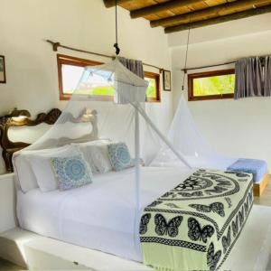 a bedroom with a white bed with a canopy at Casa Dibulla Hotel Boutique in Dibulla +56 photos
