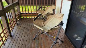 a stroller sitting on the porch of a house at ペットと泊まれる貸別荘南阿蘇久木野の郷 in Minami Aso