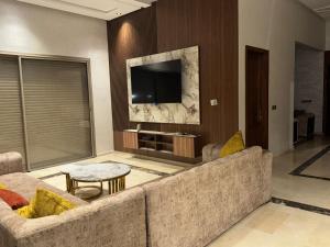 a living room with a couch and a tv at villas d'or in Marrakech