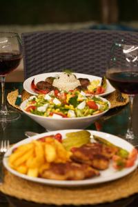 two plates of food on a table with wine glasses at Portakal Bahçesi Bungalow Hotel in Kumluca +23 photos