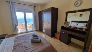 a bedroom with a bed and a mirror and a balcony at Alexandras Villa in Skala Marion