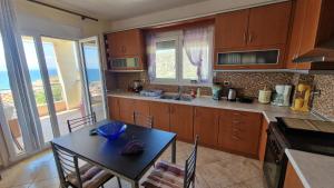 a kitchen with a table and a table and chairs at Alexandras Villa in Skala Marion