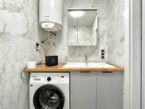a kitchen with a washing machine and a sink at Voloshyna Central Loft in Ivano-Frankivsk