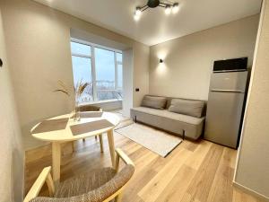 a living room with a table and a couch at Voloshyna Central Loft in Ivano-Frankivsk