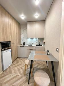 a small kitchen with a table and two chairs at Voloshyna Central Loft in Ivano-Frankivsk +24 photos
