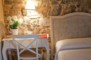 a bedroom with a table and a chair next to a bed at A Casa da Torre Branca in Santiago de Compostela +27 photos