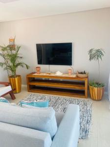 a living room with a flat screen tv on the wall at Duplex vista mar acomoda até 12 pessoas com piscina e estacionamento privativo in Canoa Quebrada