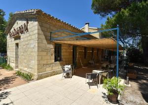 un edificio con un patio con mesas y sillas en Mas de la Tour Carbonnière, en Aigues-Mortes