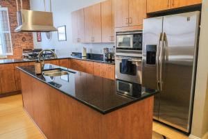 a kitchen with stainless steel appliances and wooden cabinets at 1800 Sq Ft Loft Downtown Near Convention Center in Indianapolis