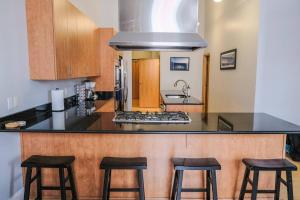 a kitchen with a counter with three bar stools at 1800 Sq Ft Loft Downtown Near Convention Center in Indianapolis