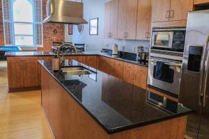 a kitchen with a black counter top with a sink at 1800 Sq Ft Loft Downtown Near Convention Center in Indianapolis +27 photos