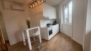 a white kitchen with a sink and a stove at 100 m de la mer, Sauna, Wifi in Mers-les-Bains