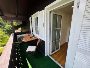 a screened porch with a table and a chair at Modernes Apartment mit Balkon zwischen Chiemsee und Kampenwand in Bernau am Chiemsee +6 photos