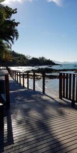 a wooden boardwalk leading to the water on a beach at Casa a 10 minutos a pé da praia e restaurantes in Porto Belo