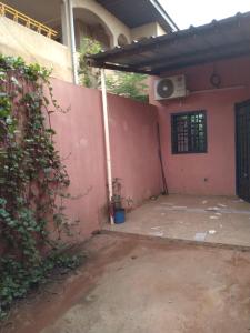 an outside view of a house with a pink wall at Hollande House Blm in Ouagadougou