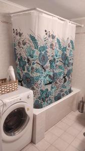 a washing machine in a bathroom with a shower curtain at Epiphany Moudros Apartment in Moúdhros +27 photos