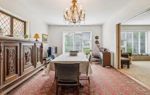 a dining room with a table and a chandelier at 3 Bedroom Lovely Home In Nykøbing M in Nykøbing Mors