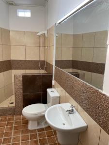 un bagno con un water bianco e un lavandino di Iquitos Confort a Iquitos