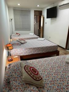 un gruppo di tre letti in una stanza di Iquitos Confort a Iquitos