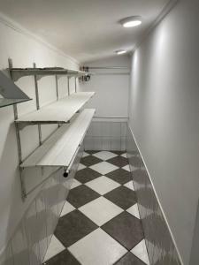 un bagno con mensole e pavimento a scacchi di Iquitos Confort a Iquitos