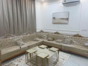 a living room with a couch and two tables at Villa awqad salalah in Salalah +1 photo